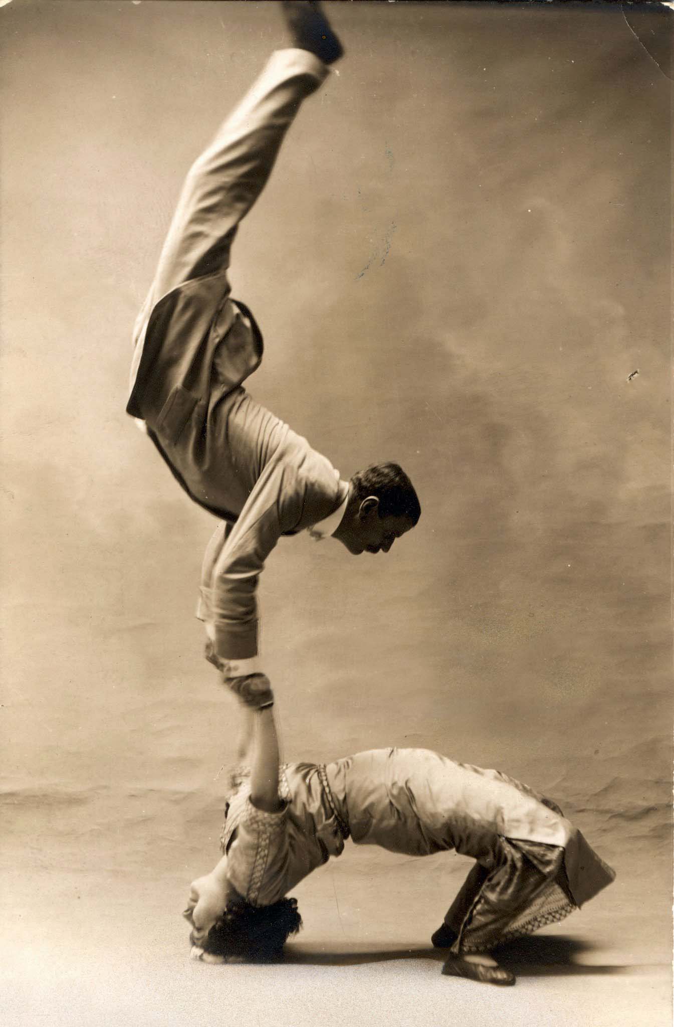 French acrobat Solea and his female assistant demonstrate their prowess at balancing for a portrait in a photographer's studio, France, 1900s