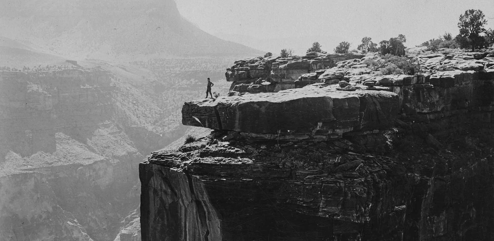 Photograph of a person on the edge of a cliff in the Grand Canyon, Arizona, 1900-1940. [detail] From the USC Digital Library