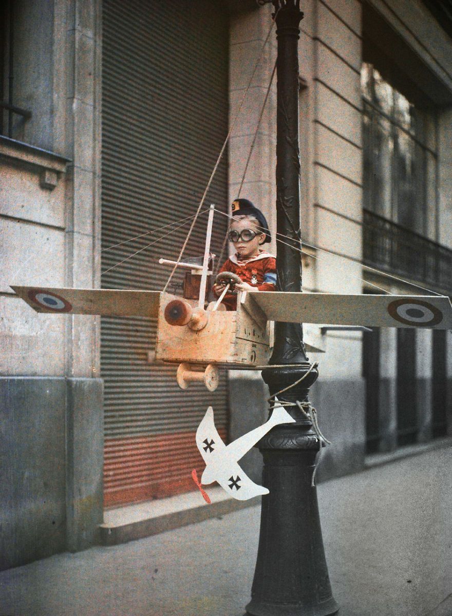 Léon Gimpel :: Boy playing in model airplane attached to a lamppost. France, 1915. Autochrome. | src Aktuallne Magazin